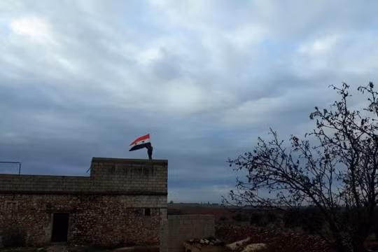 Quân đội Syria thượng cờ trên nóc nhà cao tầng của thành phố Manbij, Aleppo.