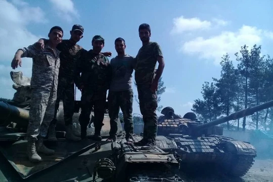 Binh sĩ lực lượng vũ trang địa phương NDF trên xe tăng quân đội Syria