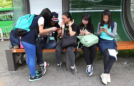 Thiếu niên Hàn Quốc sử dụng smartphone tại nhà chờ xe buýt ở Seoul.