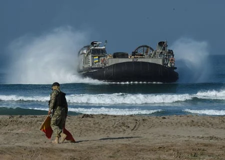 Một giám lộ viên đang dẫn đường tàu đổ bộ đêm khí trong diễn tập đổ bộ ngày 05.09, 2015. (Photo / CFP)