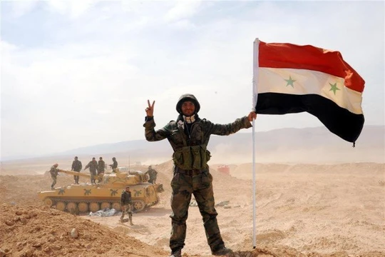 Binh sĩ Syria cùng lá cờ trên sa mạc Palmyra (ảnh minh họa)