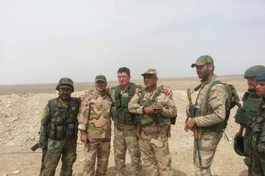 Một binh sĩ lực lượng hải quân đánh bộ Nga cùng với binh sĩ Syria trên chiến trường Palmyra