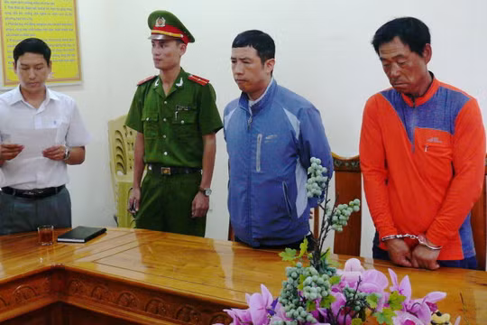 Cơ quan công an đọc lệnh khởi tố bắt tạm giam đối với Lee Jae Myecong (áo đỏ) và Jong Wook (áo khoác xanh) - Ảnh: Văn Định