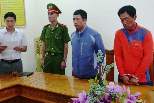 Cơ quan công an đọc lệnh khởi tố bắt tạm giam đối với Lee Jae Myecong (áo đỏ) và Jong Wook (áo khoác xanh) - Ảnh: Văn Định