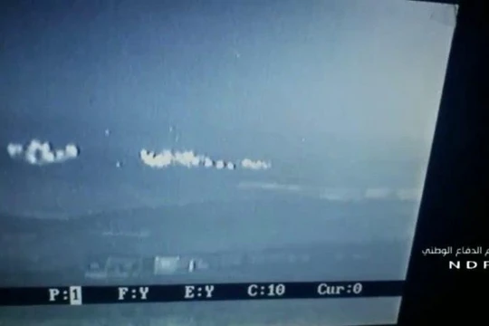 Cảnh pháo phản lực Grad tấn công nhóm chiến binh HTS trên vùng nông thôn Bắc Hama trên màn hinh UAV - ảnh Muraselon