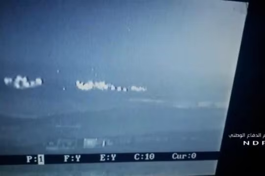 Cảnh pháo phản lực Grad tấn công nhóm chiến binh HTS trên vùng nông thôn Bắc Hama trên màn hinh UAV - ảnh Muraselon