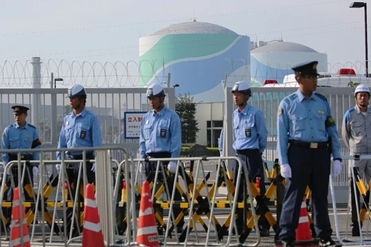 Cảnh sát đứng canh gác ngoài khu Tổ hợp hạt nhân Sendai, ngăn chặn người biểu tình phản đối tái khởi động chương trình.