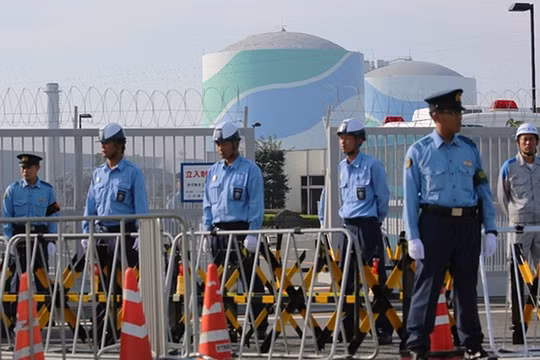 Cảnh sát đứng canh gác ngoài khu Tổ hợp hạt nhân Sendai, ngăn chặn người biểu tình phản đối tái khởi động chương trình.