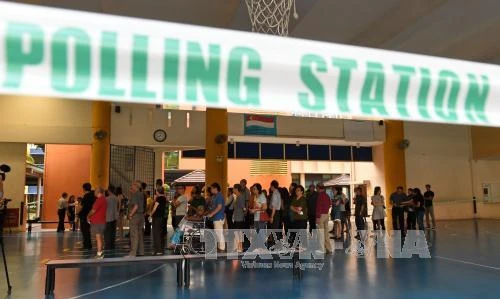 Cử tri Singapore chờ bỏ phiếu tại một điểm bầu cử ở Singapore ngày 11/9. Ảnh: AFP/TTXVN