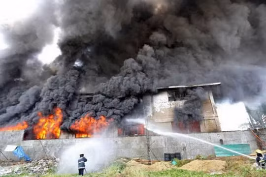 Nhân viên cứu hỏ nỗ lực dập tắt ngọn lửa tại nhà máy ở ngoại ô Valenzuela Ảnh: AFP