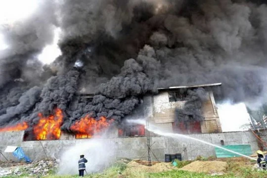 Nhân viên cứu hỏ nỗ lực dập tắt ngọn lửa tại nhà máy ở ngoại ô Valenzuela Ảnh: AFP