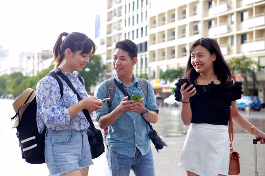 Các bạn trẻ sử dụng wifi miễn phí trên phố đi bộ Nguyễn Huệ. Nguồn Thanh Niên 