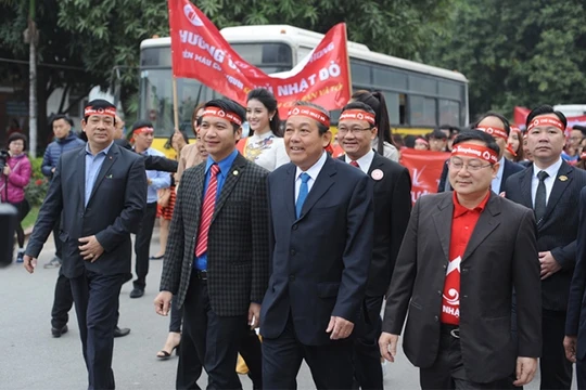 Phó Thủ tướng thường trực Chính phủ Trương Hòa Bình và các đại biểu tham gia diễu hành hưởng ứng Ngày hội Chủ nhật đỏ 8/1/2017.