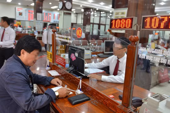 Khách hàng giao dịch tại một ngân hàng ở Q.1, TP.HCM - Ảnh: D.Ph. 