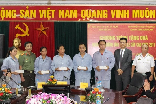 Ông Kim Dong Ji (áo đen) và Trung tướng Nguyễn Văn Tình (áo trắng) thay mặt Ban tổ chức trao quà cho các bệnh nhân. Ảnh: Thuần Phong