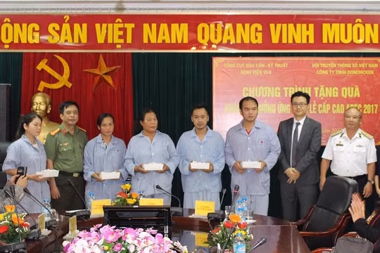Ông Kim Dong Ji (áo đen) và Trung tướng Nguyễn Văn Tình (áo trắng) thay mặt Ban tổ chức trao quà cho các bệnh nhân. Ảnh: Thuần Phong