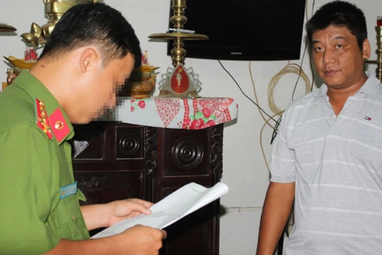 Công an đọc lệnh bắt tạm giam ông Bùi Văn Minh - Ảnh: Phan Tại/Tuổi trẻ