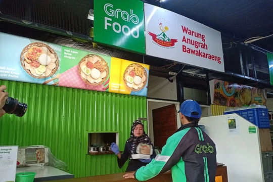 Tài xế GrabFood tới nhận đồ ăn ở quầy hàng tại GrabKitchen (ảnh chụp tại Indonesia).