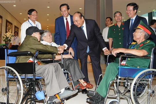 Thủ tướng thăm hỏi các đồng chí thương binh nặng tới dự buổi gặp mặt.
