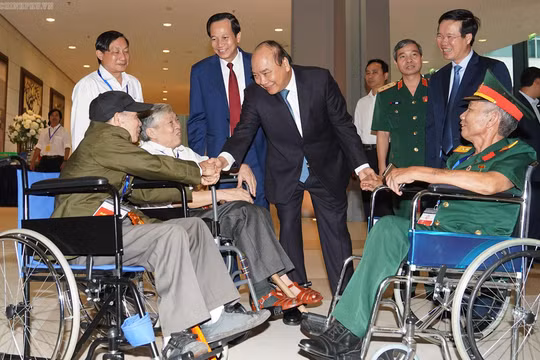 Thủ tướng thăm hỏi các đồng chí thương binh nặng tới dự buổi gặp mặt.