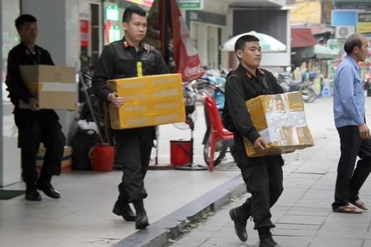 Khám xét chuỗi cửa hàng Nhật Cường, cảnh sát thu giữ hàng nghìn điện thoại, tài liệu liên quan. Ảnh: Hoàng Lam.