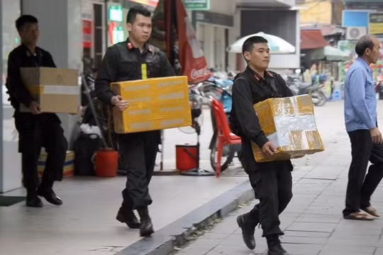 Khám xét chuỗi cửa hàng Nhật Cường, cảnh sát thu giữ hàng nghìn điện thoại, tài liệu liên quan. Ảnh: Hoàng Lam.