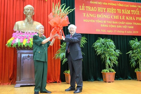 Tổng Bí thư, Chủ tịch nước Nguyễn Phú Trọng, Bí thư Quân ủy Trung ương trao Huy hiệu 70 năm tuổi Đảng tặng ông Lê Khả Phiêu, nguyên Tổng Bí thư Ban Chấp hành Trung ương Đảng Cộng sản Việt Nam, nguyên Chủ nhiệm Tổng cục Chính trị Quân đội nhân dân Việt Nam