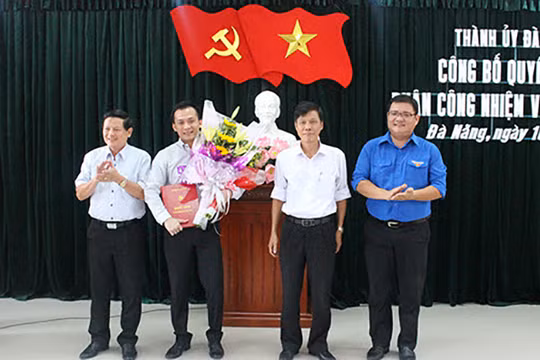 Ông Nguyễn Bá Cảnh (người cầm hoa) tại buổi công bố quyết định