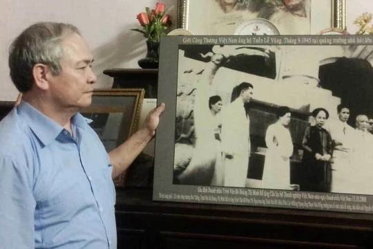 Ông Trịnh Cần Chính bên bức ảnh chụp cha, mẹ và bà nội trong "Tuần Lễ Vàng". Ảnh: Diệu Bình/Vietnamnet.