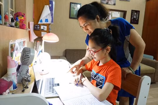 Phụ huynh trợ giúp con khi học trực tuyến - Ảnh: Hanoimoi.com.vn