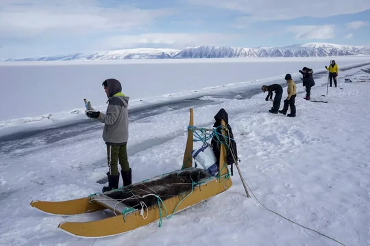 Dân làng đánh cá dọc theo một vết nứt trên băng biển vào năm 2023 tại Qaanaaq, Greenland. Ảnh: Washington Post.