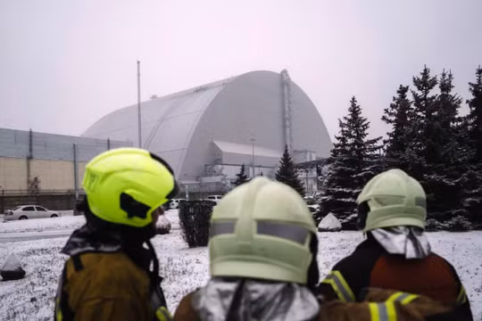 Nhân viên cứu hộ theo dõi mọi người kiểm tra thiệt hại ở tấm chắn bức xạ của Lò phản ứng số 4 tại địa điểm Chernobyl sau cuộc tấn công bằng UAV ngày 14/2. Ảnh: Getty.