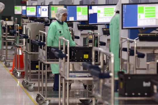 Công nhân trong một nhà máy ở Singapore nhập dữ liệu công việc vào các phương tiện tự động (Ảnh: AP)