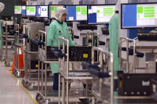 Công nhân trong một nhà máy ở Singapore nhập dữ liệu công việc vào các phương tiện tự động (Ảnh: AP)