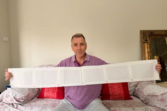 Laurence Watkins, một nhân viên bảo vệ đã nghỉ hưu đến từ Auckland, New Zealand, cầm trên tay giấy khai sinh dài 6 trang, trong đó ghi đầy đủ 2.253 cái tên của ông. Ảnh: CNN.