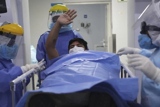 Một bệnh nhân được chuyển ra khỏi khu điều trị đặc biệt ở Lima, Peru (Ảnh: AP)