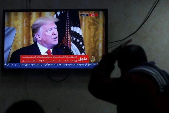Một người Palestine theo dõi ông Trump tuyên bố kế hoạch hòa bình Trung Đông qua truyền hình (Ảnh: Reuters)