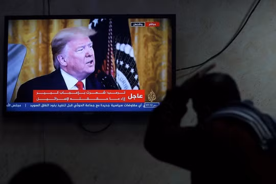 Một người Palestine theo dõi ông Trump tuyên bố kế hoạch hòa bình Trung Đông qua truyền hình (Ảnh: Reuters)
