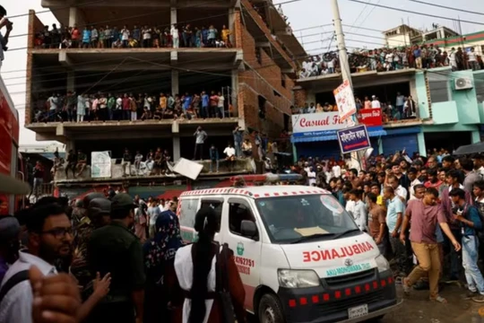 Một xe cứu thương đi qua gần hiện trường sau khi một máy bay huấn luyện của không quân đâm vào khuôn viên trường Cao đẳng Milestone, tại Dhaka, Bangladesh vào ngày 21/7. Ảnh: Reuters.