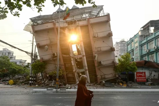Một nhà sư đi ngang qua một tòa nhà bị sập ở Mandalay vào ngày 1/4, vài ngày sau trận động đất kinh hoàng ở Myanmar. Ảnh: AFP.