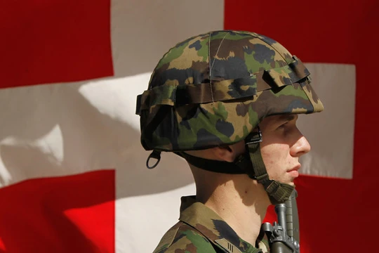 Một người lính Thụy Sĩ đứng trước lá quốc kỳ (Ảnh: Getty)