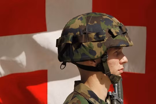 Một người lính Thụy Sĩ đứng trước lá quốc kỳ (Ảnh: Getty)