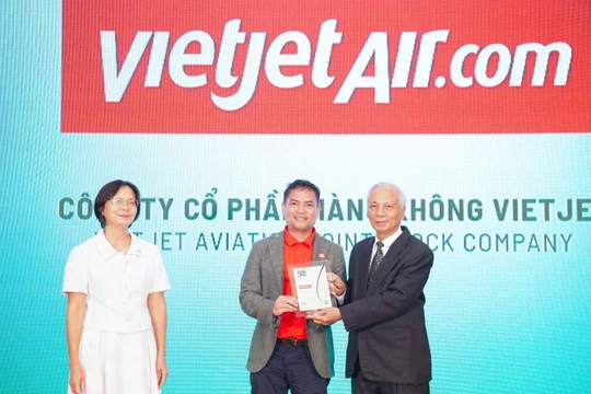 Ông Nguyễn An Di, Giám đốc Nhân sự Vietjet (giữa), nhận giải thưởng tôn vinh Top 50 doanh nghiệp phát triển bền vững từ ban tổ chức