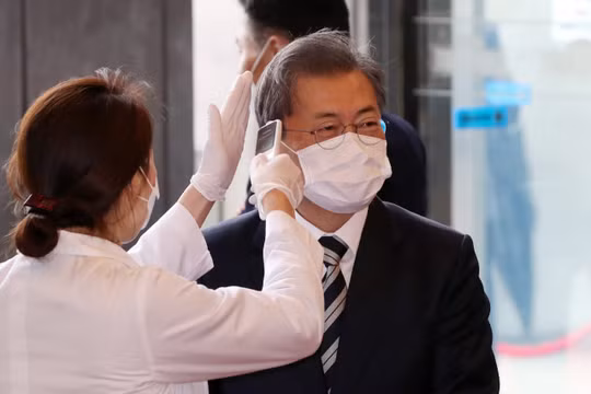 Tổng thống Hàn Quốc Moon Jae-in được đeo khẩu trang và kiểm tra thân nhiệt trước khi vào tòa nhà Quốc hội ở Seoul trong hôm 28/2 (Ảnh: Yonhap)