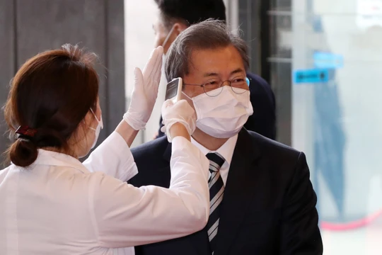 Tổng thống Hàn Quốc Moon Jae-in được đeo khẩu trang và kiểm tra thân nhiệt trước khi vào tòa nhà Quốc hội ở Seoul trong hôm 28/2 (Ảnh: Yonhap)