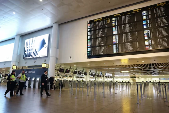 Nhân viên đi ngang qua bảng thông báo khởi hành tại Sân bay Brussels sau khi cơ quan kiểm soát không lưu Bỉ báo cáo phát hiện một UAV tại Zaventem, Bỉ, ngày 4/11. Ảnh: Reuters.