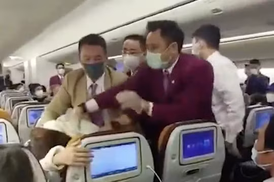 Một bức ảnh chụp cho thấy nữ hành khách Trung Quốc bị khống chế sau khi ho vào nữ tiếp viên của hãng Thai Airways (Ảnh: Handout)