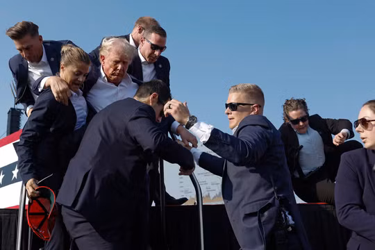 Cựu Tổng thống Donald Trump được các nhân viên Sở Mật vụ bảo vệ ra khỏi sân khấu (Ảnh: Getty)