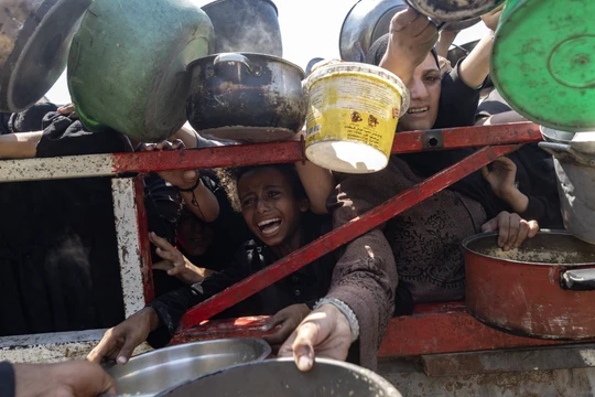 Người Palestine chờ đợi trước một bếp ăn từ thiện ở phía tây thành phố Gaza trong hôm 23/7. Những bếp ăn này được tài trợ bởi các nước Arab, phương Tây và các tổ chức cứu trợ. Ảnh: NYTimes.