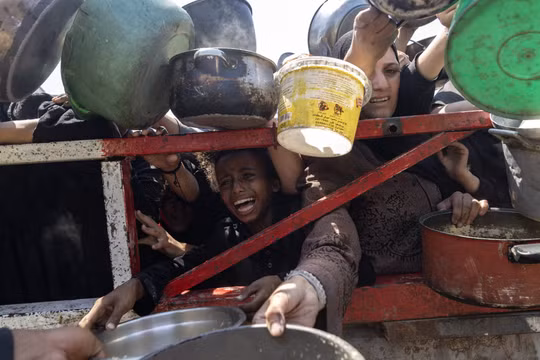 Người dân ở Gaza tại một điểm phát thức ăn miễn phí. Ảnh: Reuters.